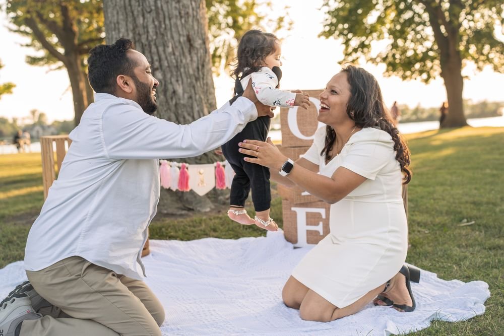 One year old walking with her parents at a Windsor first birthday session