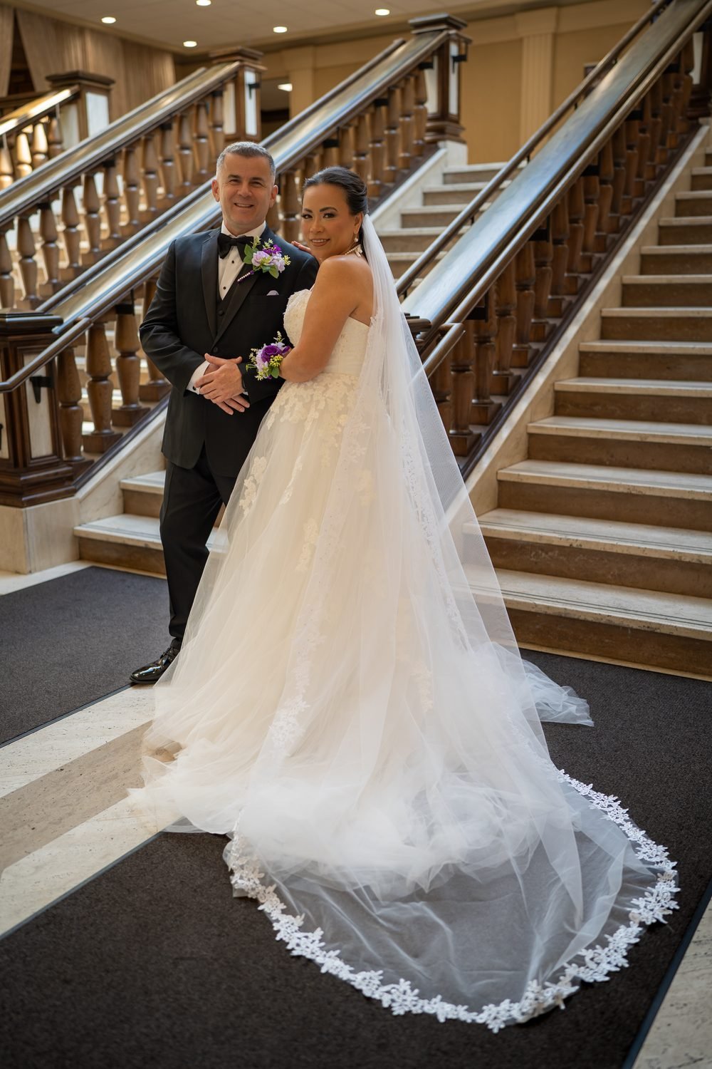 Bride's cathedral-length lace veil spread below the grand staircase at the Giovanni Caboto Club, Windsor