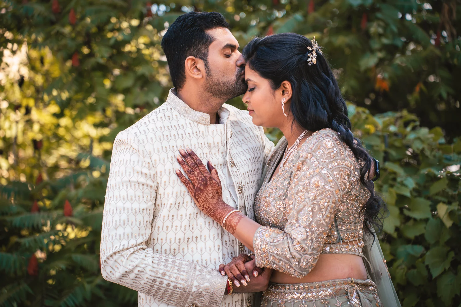 Groom kissing his bride's forehead at a South Asian engagement in Windsor, Ontario